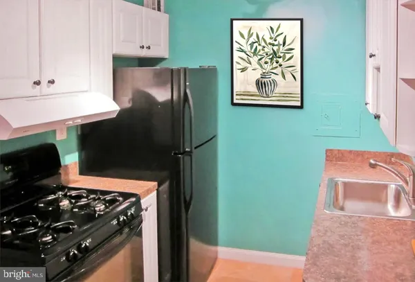 a kitchen with a refrigerator and a stove top oven