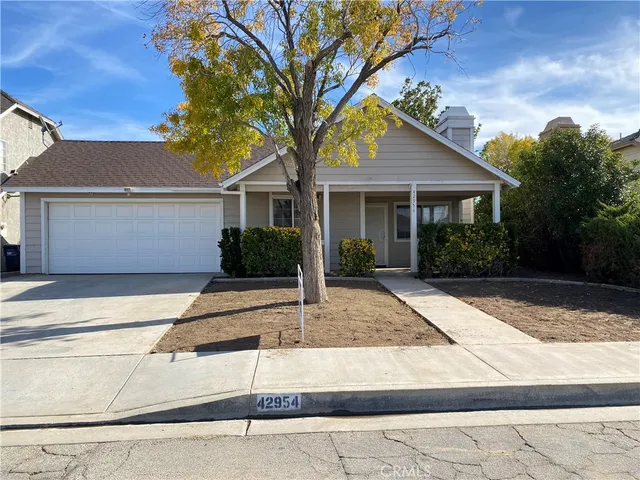 a front view of house with yard and trees around