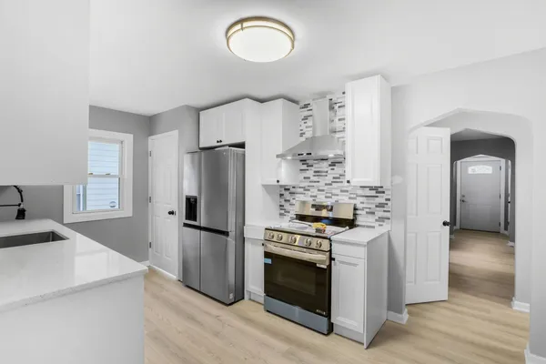 a kitchen with stainless steel appliances granite countertop a refrigerator and a stove