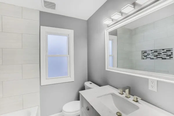 a bathroom with a sink mirror and toilet