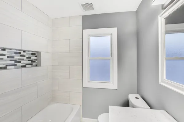 a bathroom with a toilet a sink and mirror