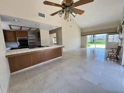 a living room with stainless steel appliances kitchen island granite countertop furniture and a fireplace