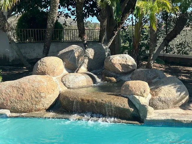 a couple of white chairs sitting in a backyard with swimming pool
