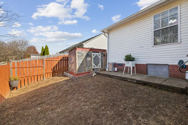 a view of backyard with deck and wooden fence
