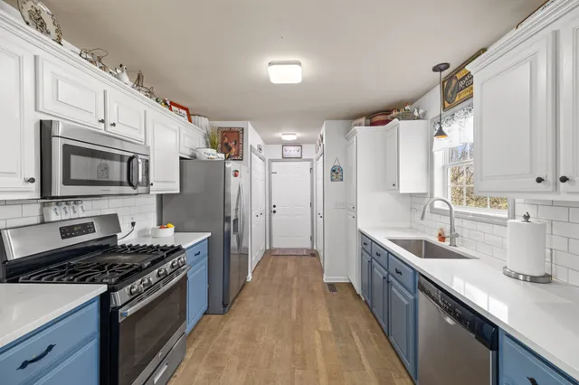 a kitchen with stainless steel appliances a sink dishwasher stove and refrigerator