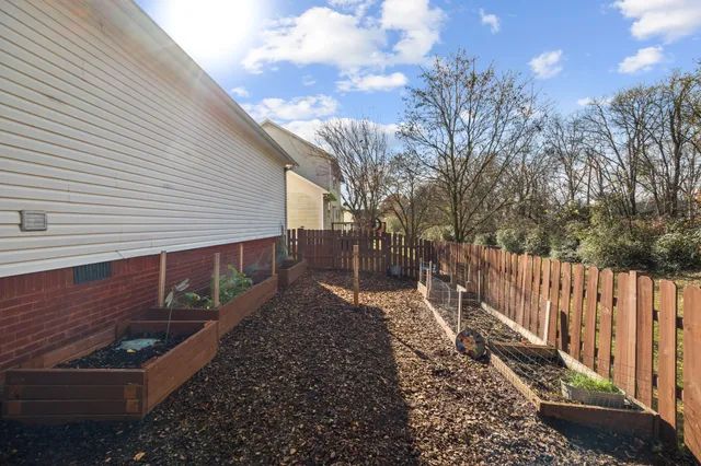 a view of a pathway of a house with wooden fence