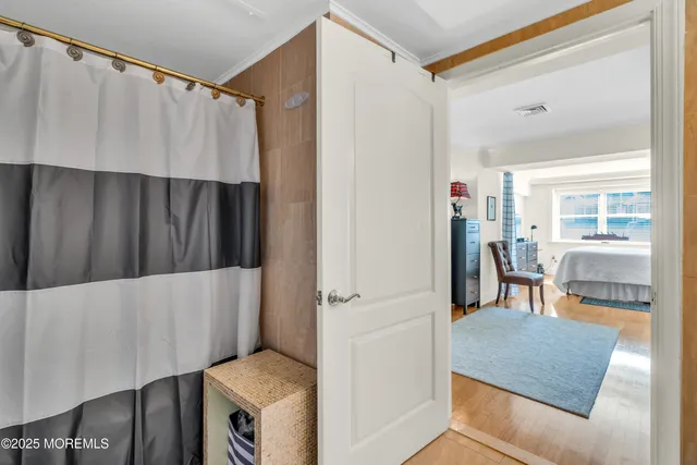 a living room with a couch and a dining table with wooden floor