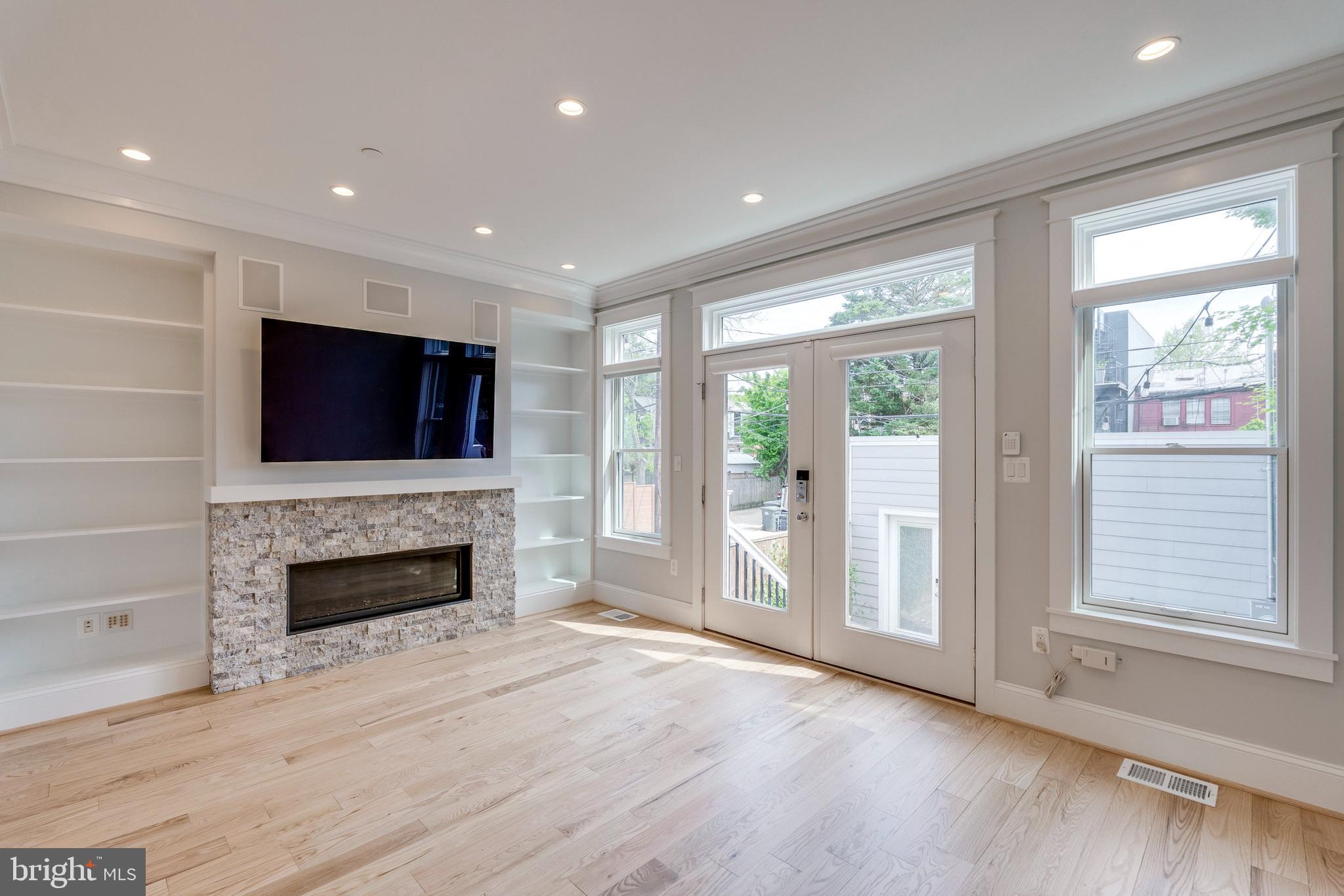 3616 T Street Northwest Washington, DC 20007 - Photo 11 of 49 an empty room with windows fireplace and wooden floor