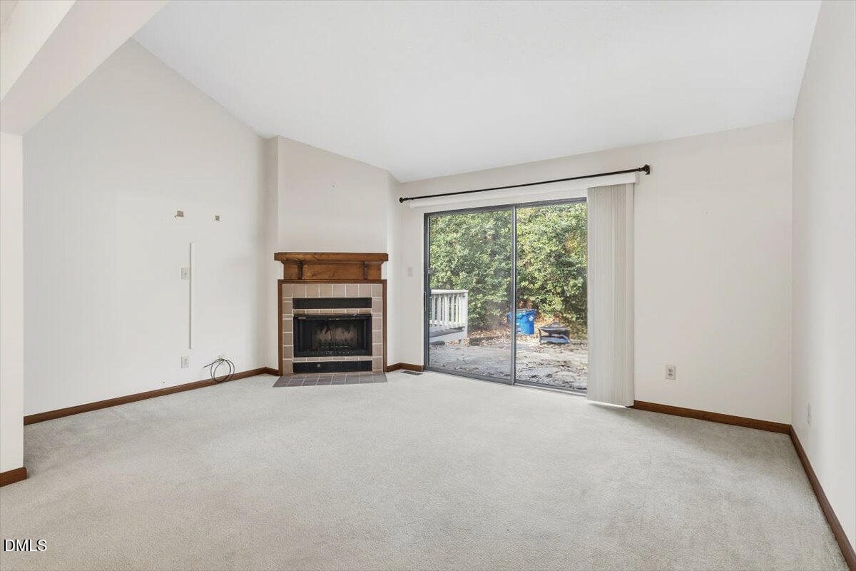 5867 Branchwood Road Raleigh, NC 27609 - Photo 11 of 24 a view of an empty room with a fireplace and a window
