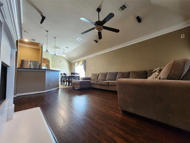 a living room with furniture and a wooden floor
