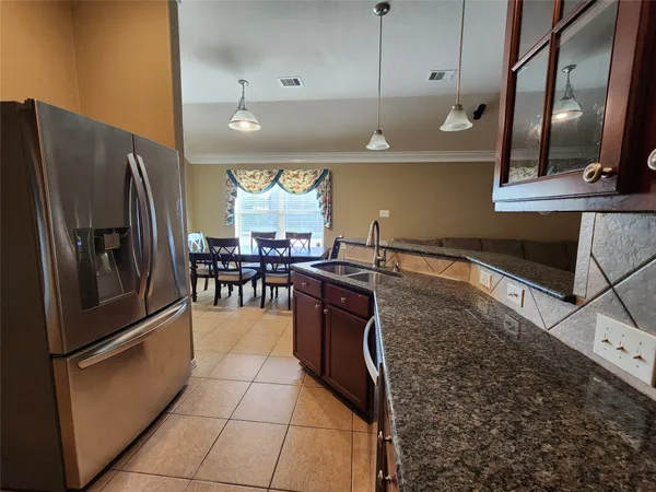 a kitchen with stainless steel appliances granite countertop a refrigerator a sink and a stove