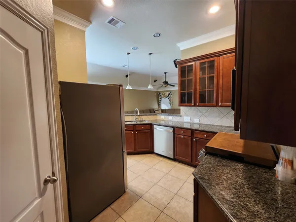 a kitchen with stainless steel appliances granite countertop a refrigerator and a sink