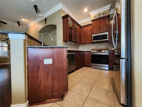 a kitchen with stainless steel appliances granite countertop a refrigerator and a sink