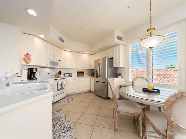 a kitchen with white cabinets and white appliances