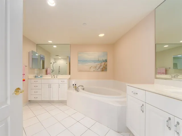 a bathroom with a granite countertop sink mirror bathtub and next