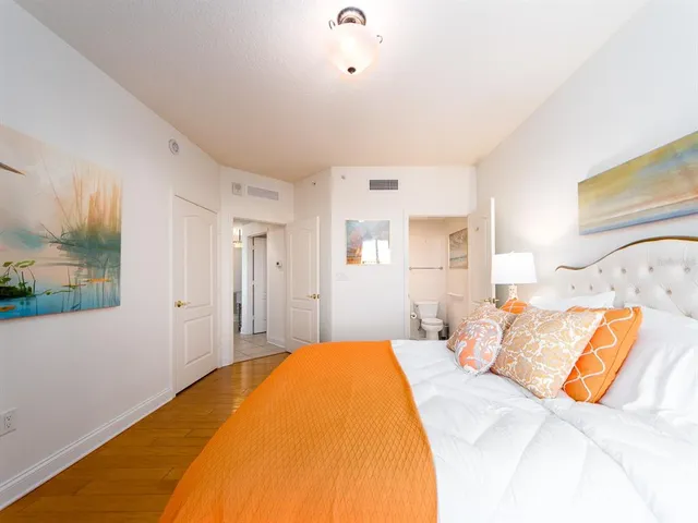 a bedroom with a bed and a painting on the wall