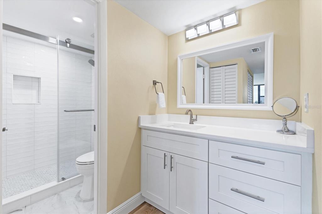 5855 Midnight Pass Road, Unit 420 Sarasota, FL 34242 - Photo 21 of 53 a bathroom with a granite countertop sink a toilet and shower