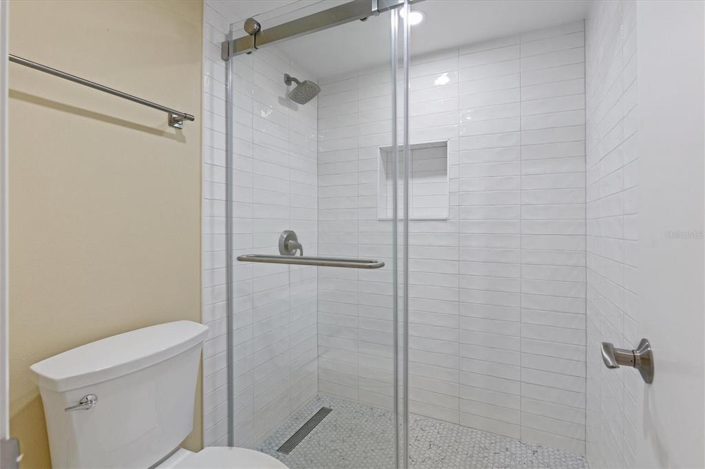 5855 Midnight Pass Road, Unit 420 Sarasota, FL 34242 - Photo 25 of 53 a bathroom with a shower a toilet and a shower