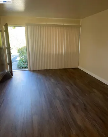 a view of a room with wooden floor and a window