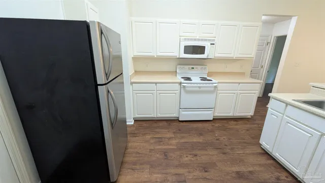 an empty room with wooden floor and a ceiling fan