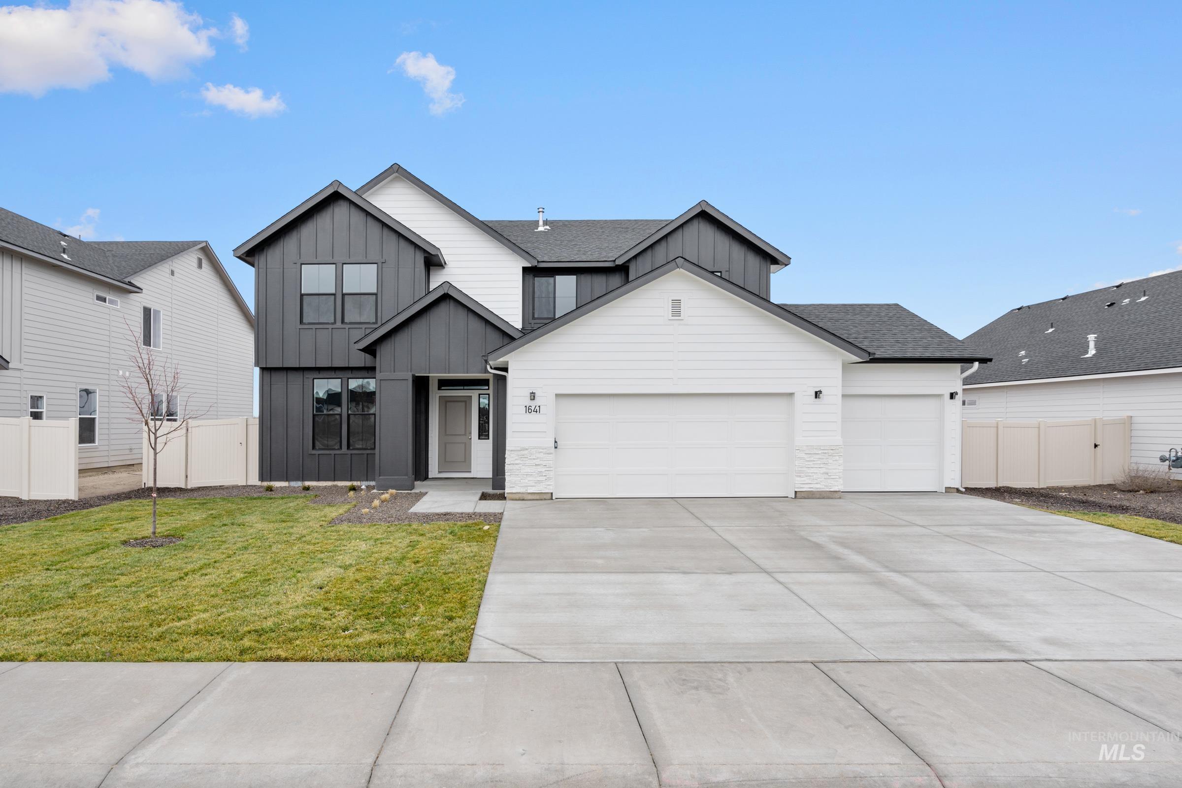 Modern farmhouse featuring board and batten siding, an attached garage, a shingled roof, and concrete driveway