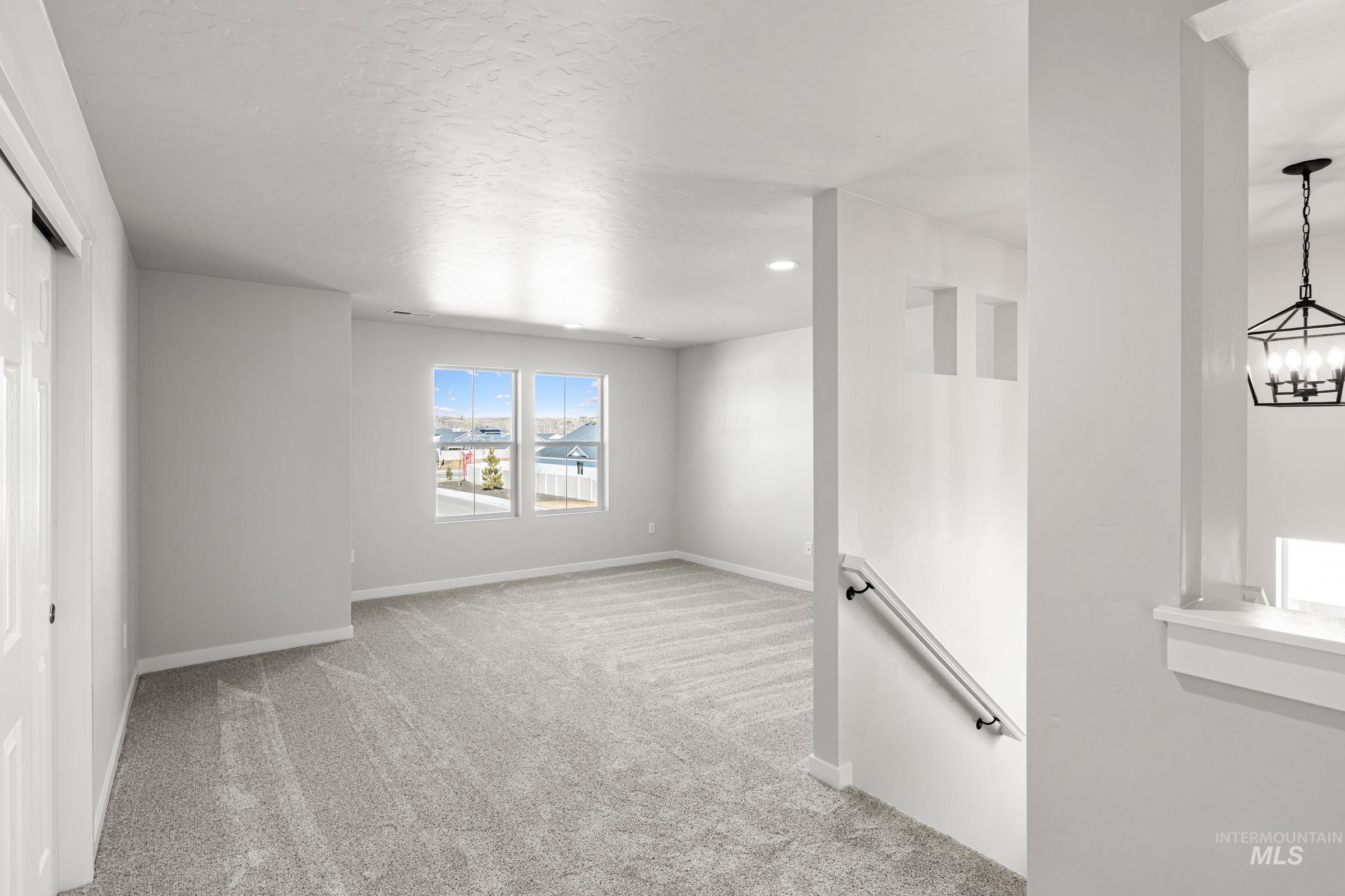 1641 Dyer Street Middleton, ID 83644 - Photo 14 of 28 Spare room featuring light colored carpet and hanging lights