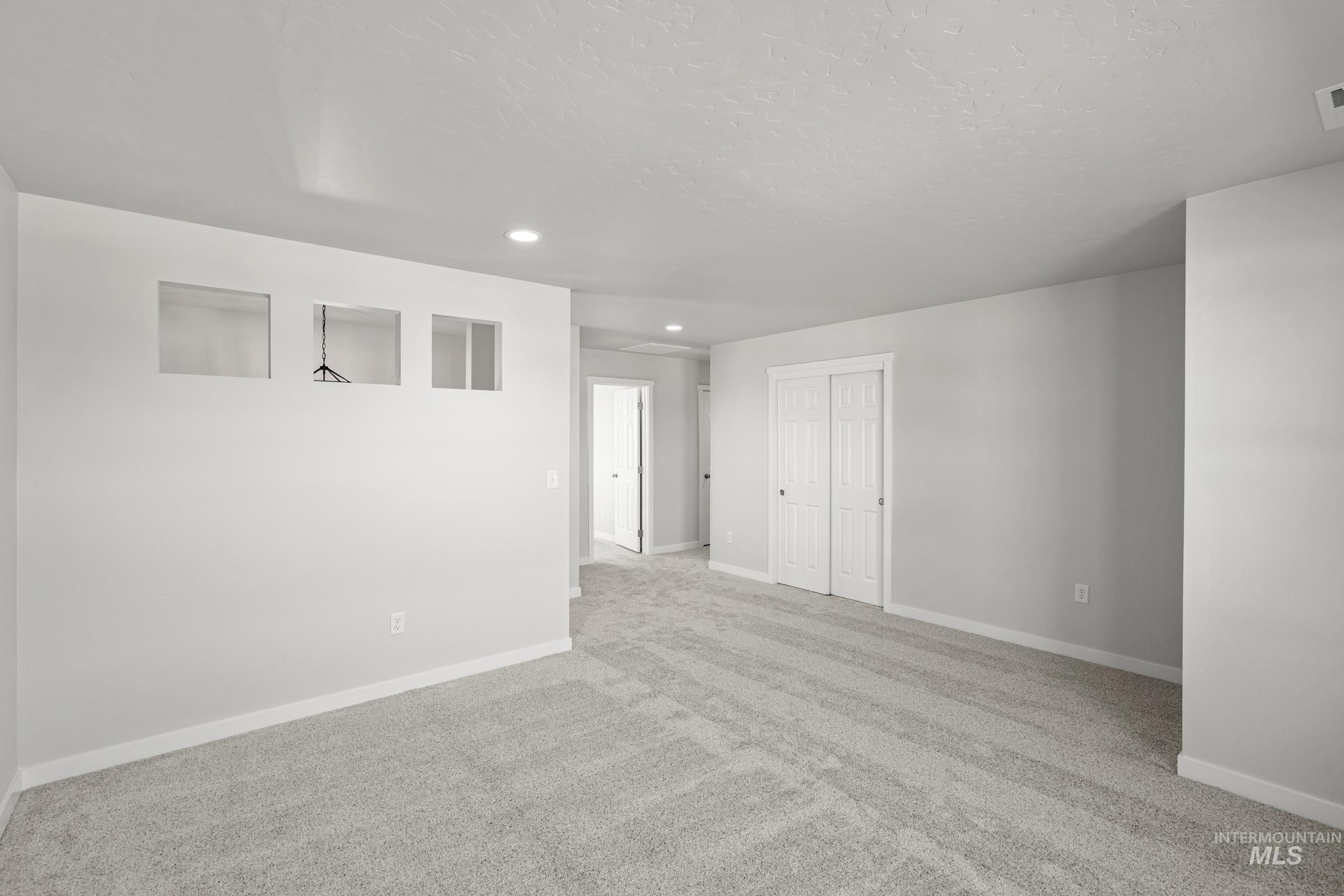 1641 Dyer Street Middleton, ID 83644 - Photo 15 of 28 Empty room featuring light carpet, recessed lighting, and a textured ceiling