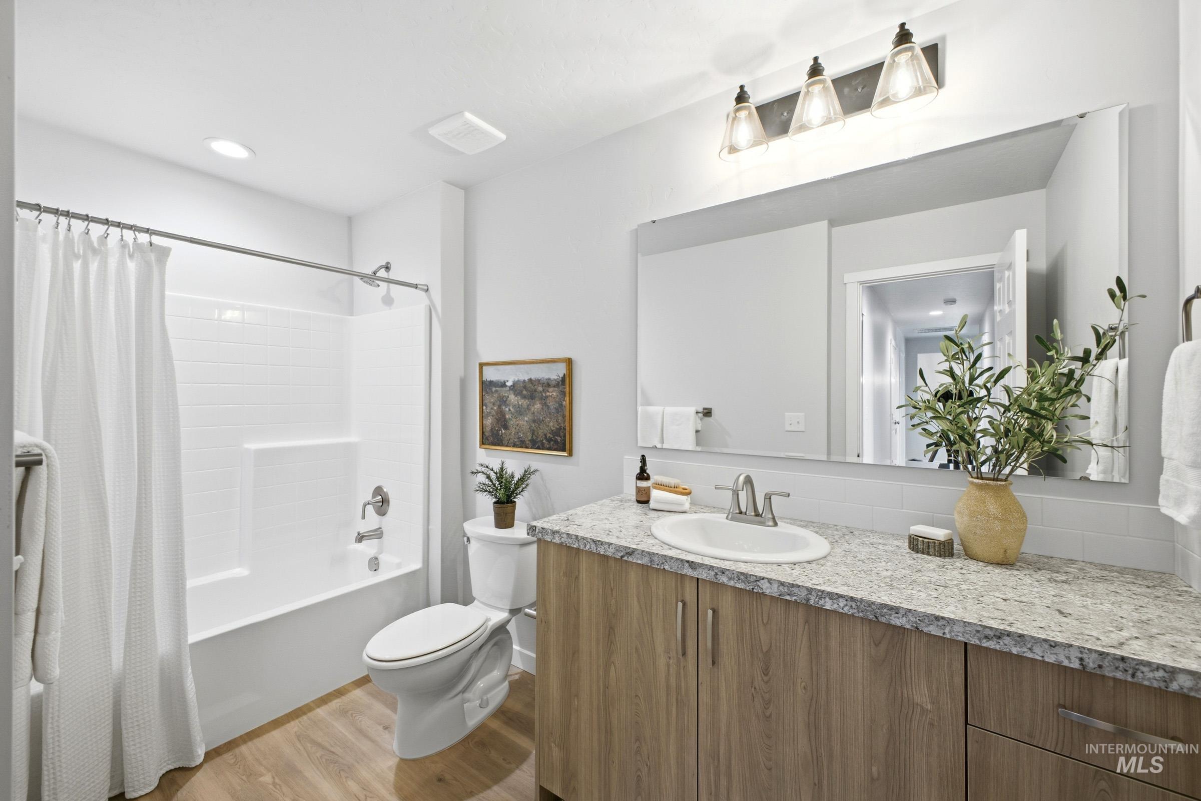 1641 Dyer Street Middleton, ID 83644 - Photo 21 of 29 Bathroom featuring vanity, shower / bath combo with shower curtain, light wood-style floors, and tasteful backsplash