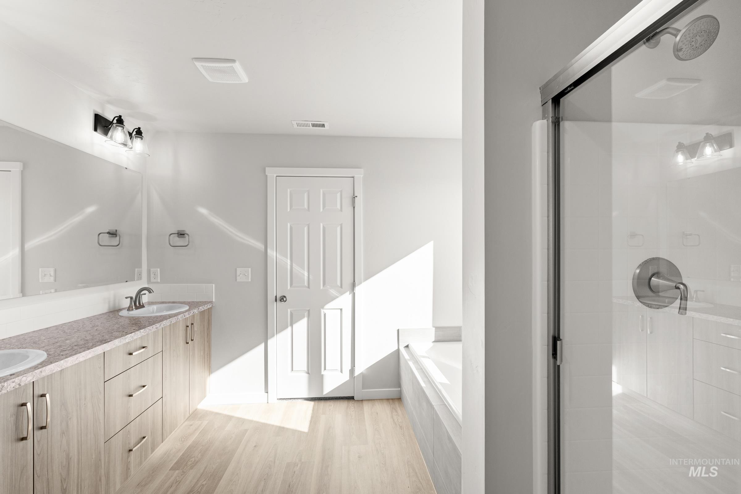 1641 Dyer Street Middleton, ID 83644 - Photo 23 of 28 Bathroom with double vanity, light wood finished floors, a garden tub, and a stall shower