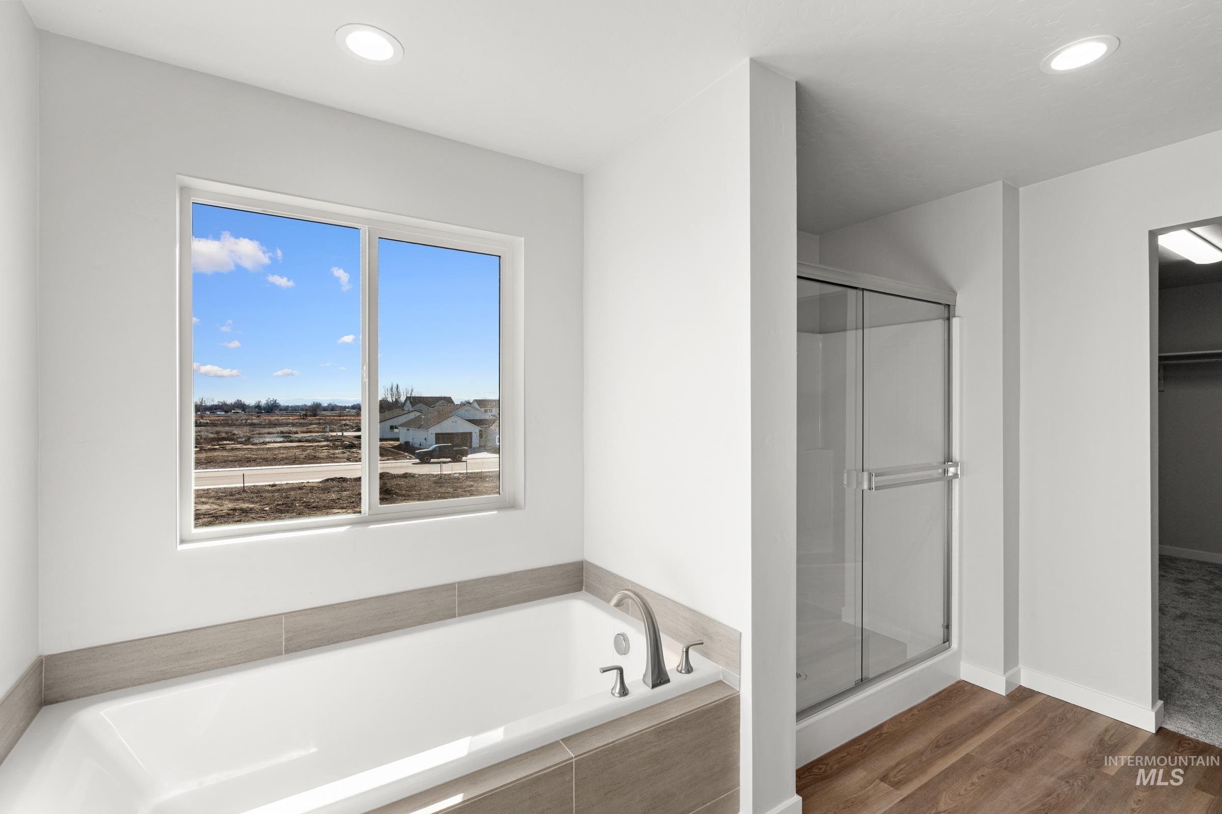 1641 Dyer Street Middleton, ID 83644 - Photo 24 of 28 Bathroom featuring a garden tub, a shower stall, recessed lighting, and dark wood-type flooring