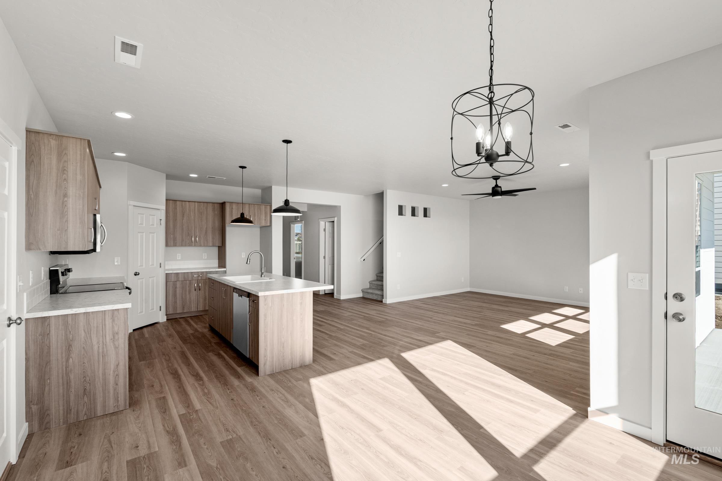 1641 Dyer Street Middleton, ID 83644 - Photo 28 of 28 Kitchen with an island with sink, suspended lighting, open floor plan, and light wood-style flooring