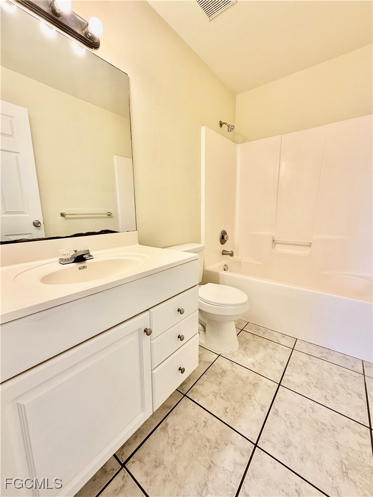 4739 28th Street Southwest Lehigh Acres, FL 33973 - Photo 14 of 14 a bathroom with a double vanity sink toilet and mirror