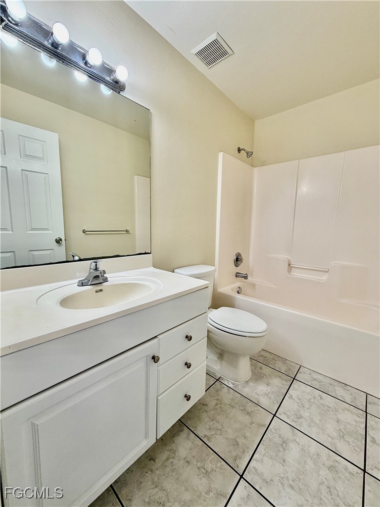 4739 28th Street Southwest Lehigh Acres, FL 33973 - Photo 7 of 14 a bathroom with a double vanity sink a toilet and a mirror