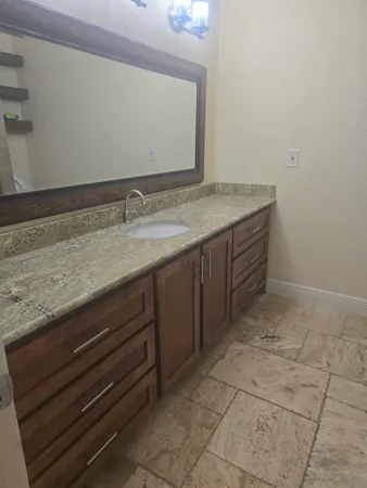 a bathroom with a granite countertop sink and vanity
