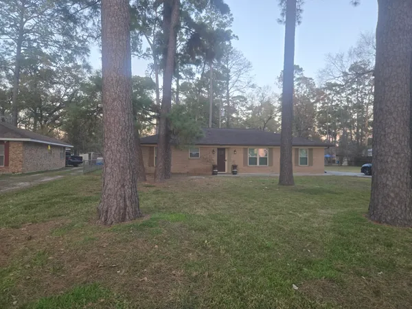 a view of a house with a yard and large tree