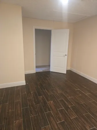 an empty room with wooden floor and closet
