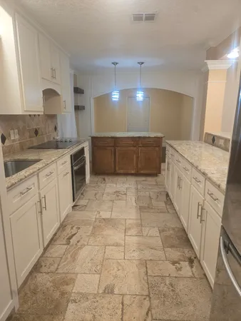 a large white kitchen with cabinets