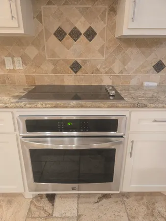 a stove top oven sitting inside of a kitchen