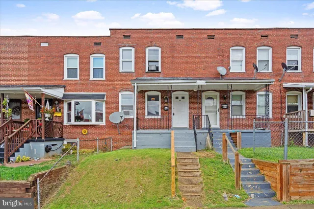 front view of a brick house with a yard