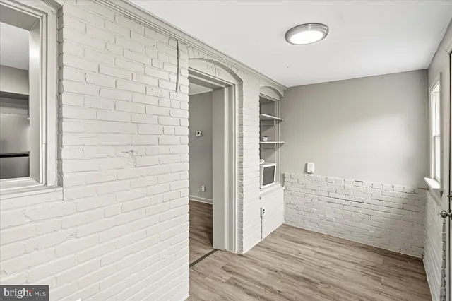 a view of a hallway with wooden floor and a livingroom