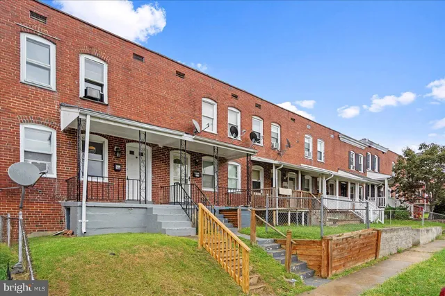 a view of an empty room with wooden floor and stairs