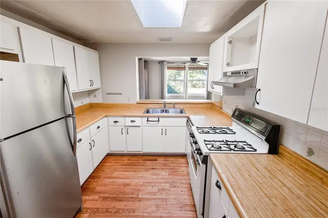 a kitchen with stainless steel appliances a refrigerator a sink and a stove