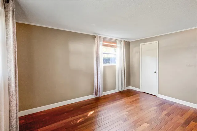 a view of an empty room with wooden floor