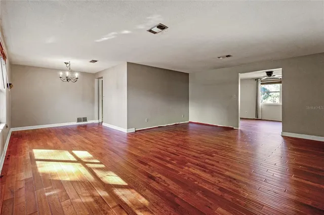 a view of empty room with wooden floor