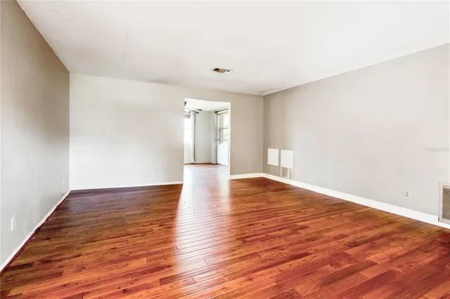 a view of empty room with wooden floor
