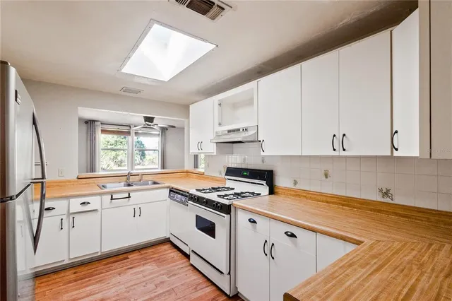 a kitchen with granite countertop white cabinets and white appliances