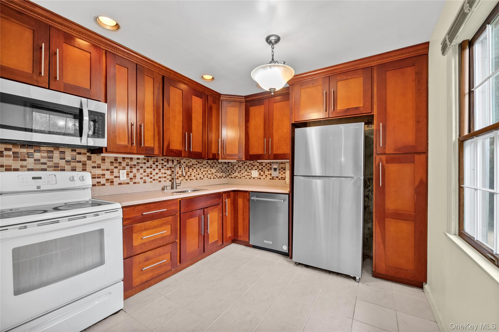 253 Raff Avenue Carle Place, NY 11514 - Photo 3 of 20 a kitchen with stainless steel appliances granite countertop a refrigerator stove top oven and sink
