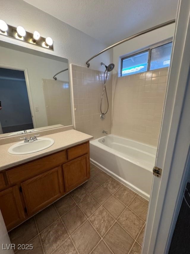 713 Rusty Spur Drive Henderson, NV 89014 - Photo 12 of 15 Bathroom with washtub / shower combination, vanity, and dark tile patterned flooring