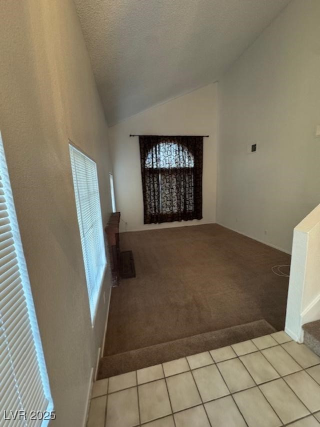 713 Rusty Spur Drive Henderson, NV 89014 - Photo 3 of 15 Entrance foyer featuring light carpet, a textured ceiling, light tile patterned floors, and high vaulted ceiling