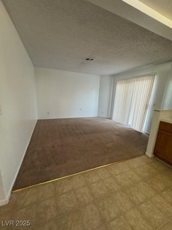 713 Rusty Spur Drive Henderson, NV 89014 - Photo 7 of 15 Unfurnished room featuring a textured ceiling and light colored carpet